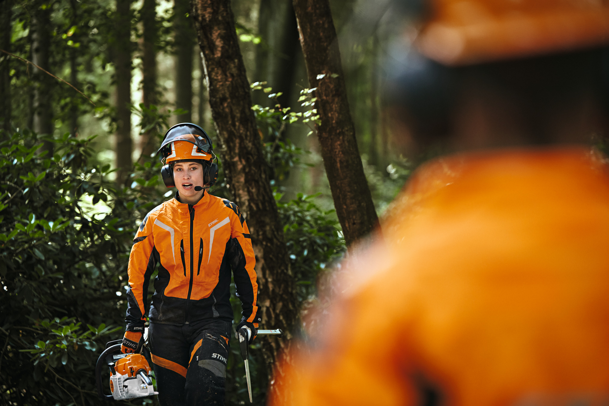 Dos trabajadores forestales con ropa de protección STIHL con el sistema de comunicación STIHL ADVANCE ProCOM