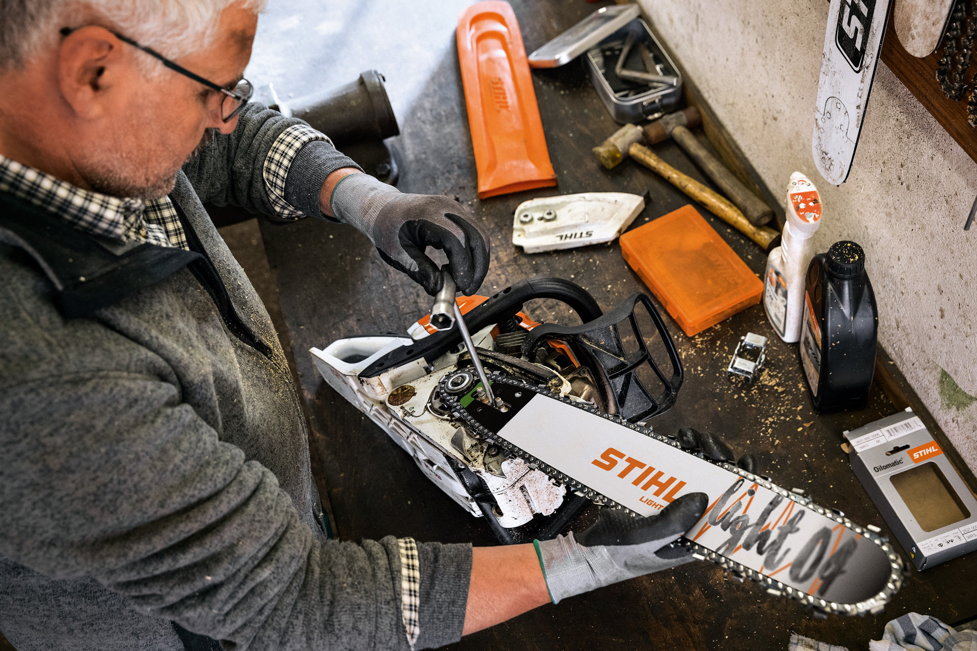 Un distribuidor especializado STIHL trabaja en una motosierra con espada Light 04 y cadena Oilomatic